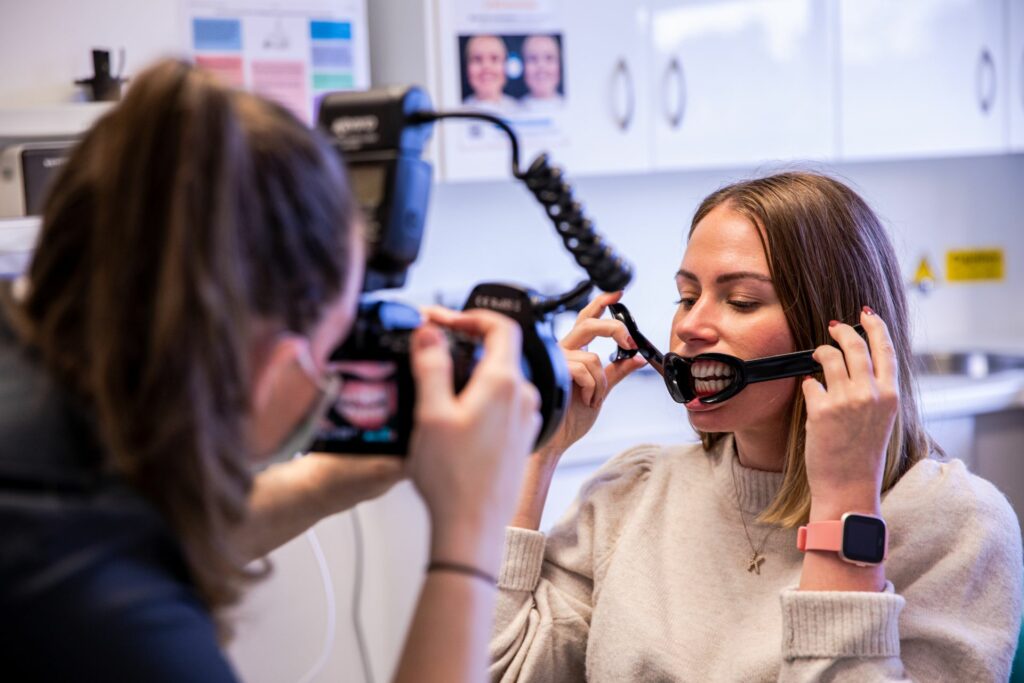Photographer taking intraoral photos of a smiling patient